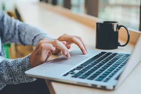 Un homme devant son pc occupé à faire une campagne adwords.
