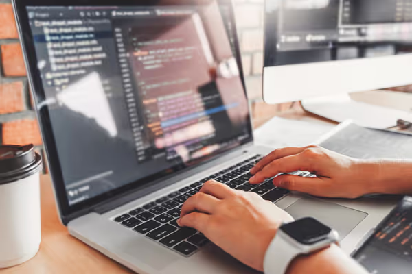 Un développeur devant son pc occupée à coder une application front-end et back-end