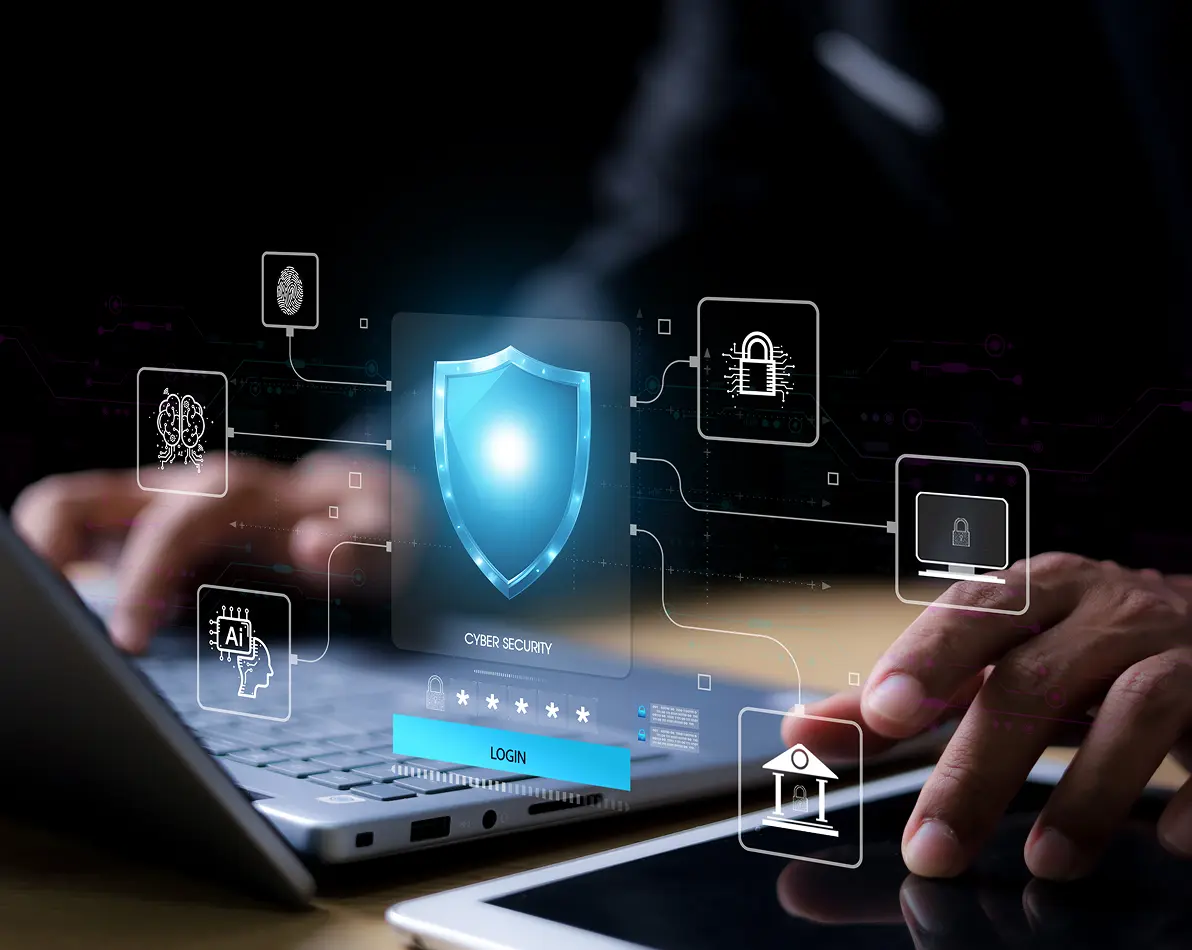 Hands typing on a laptop and tablet with holographic cybersecurity icons including shield, fingerprint, AI, lock, and login interface.