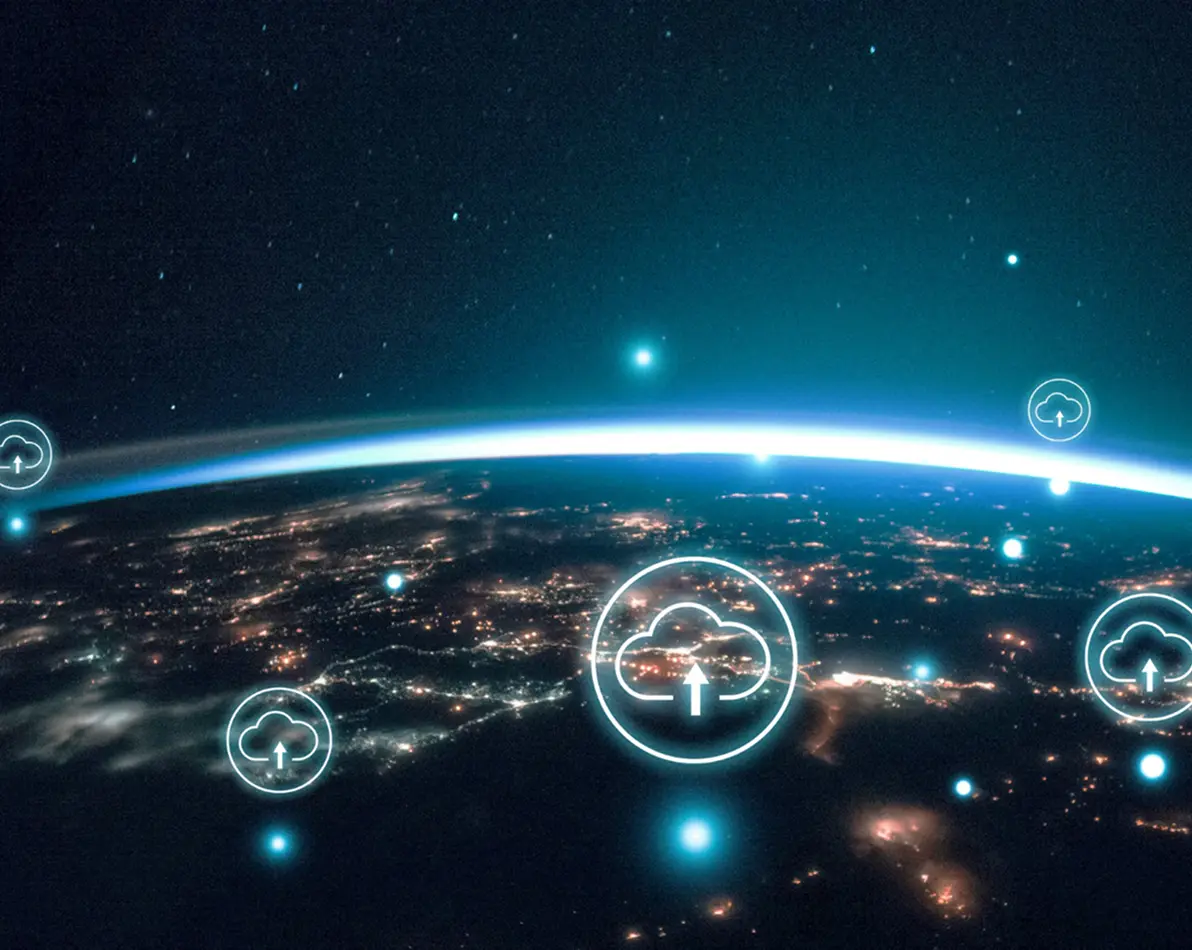 View of Earth from space at night with glowing city lights and digital cloud upload icons overlayed.