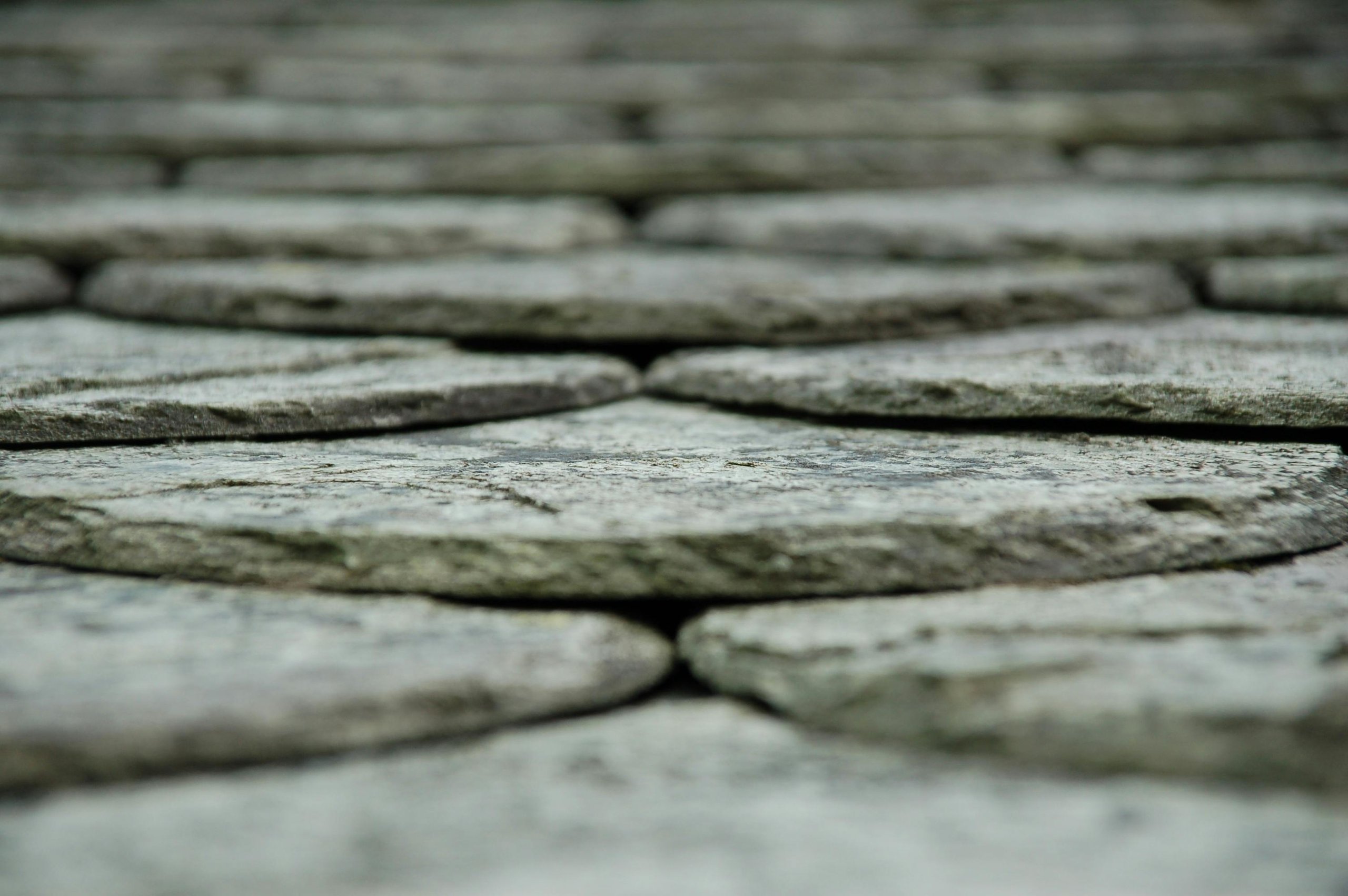 Close-up view of a stone pavement with flat, irregularly shaped stones stacked closely together.