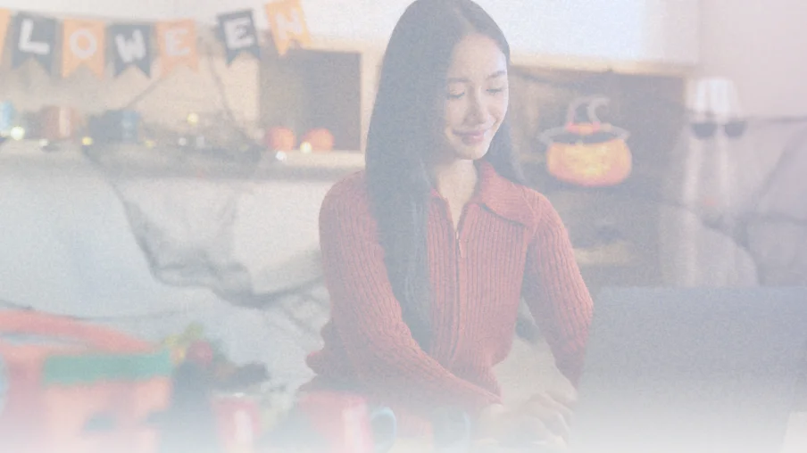 Remote employee participating in virtual Halloween celebration at home, illustrating inclusive company culture and employee engagement strategies for hybrid and remote teams