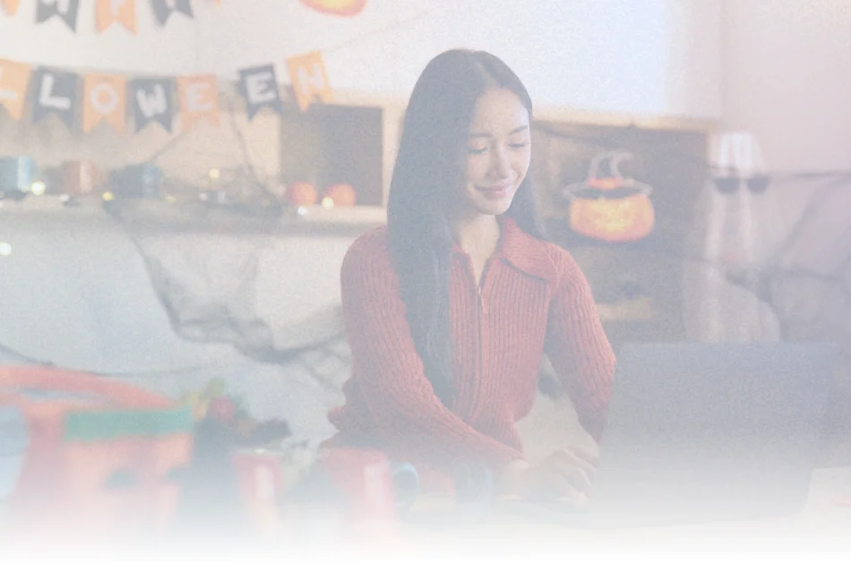 Remote employee participating in virtual Halloween celebration at home, illustrating inclusive company culture and employee engagement strategies for hybrid and remote teams