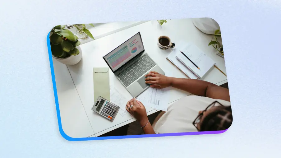 HR professional working at desk with laptop and calculator managing small business HR responsibilities and employee data