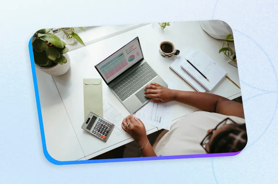 HR professional working at desk with laptop and calculator managing small business HR responsibilities and employee data