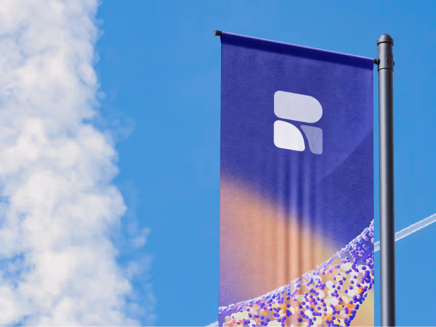 Vertical flag with a white abstract logo and colorful design on a pole against a blue sky with white clouds.