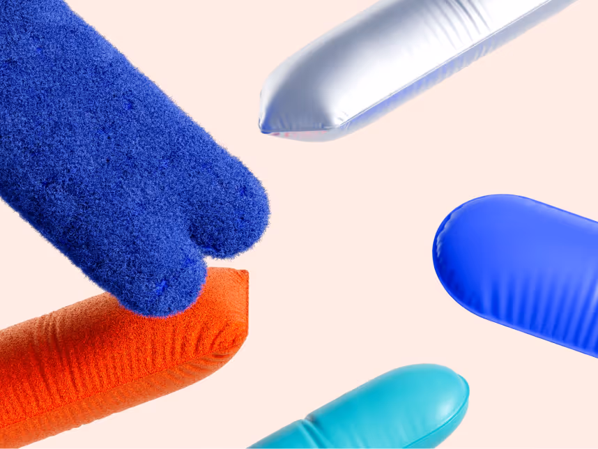 Close-up of colorful textured and smooth inflatable shapes in blue, orange, silver, and turquoise against a light background.