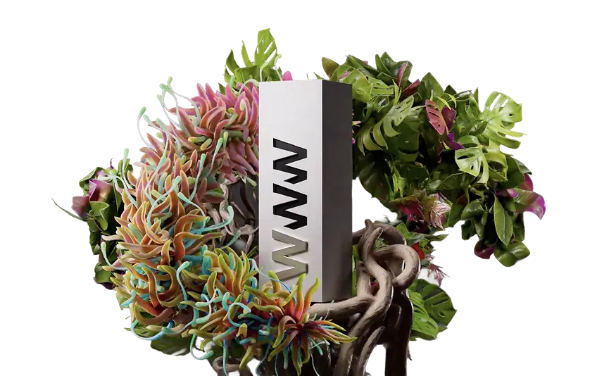 Vertical silver block with 'WWW' cut out, surrounded by colorful succulent and green leafy plants.