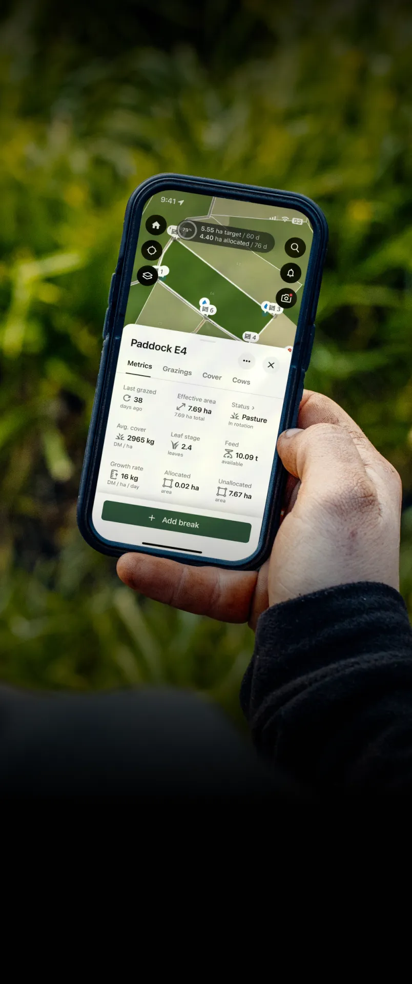 A farmer holds his phone which shows the Halter app open