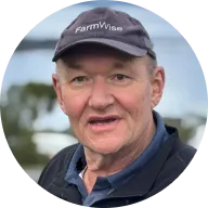 Brent Boyce wearing a “FarmWise” cap and dark jacket smiles at the camera.