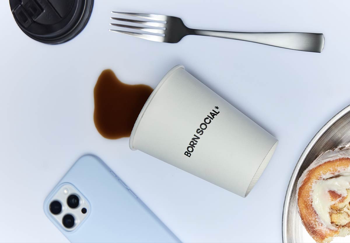 flat lay image of coffee, iphone and pastry