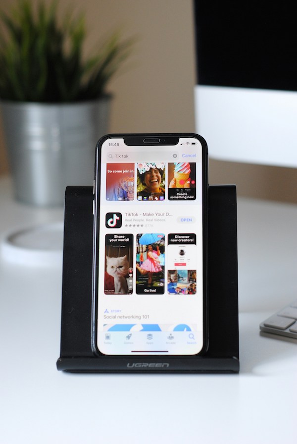 Phone's screen shows the TikTok app
