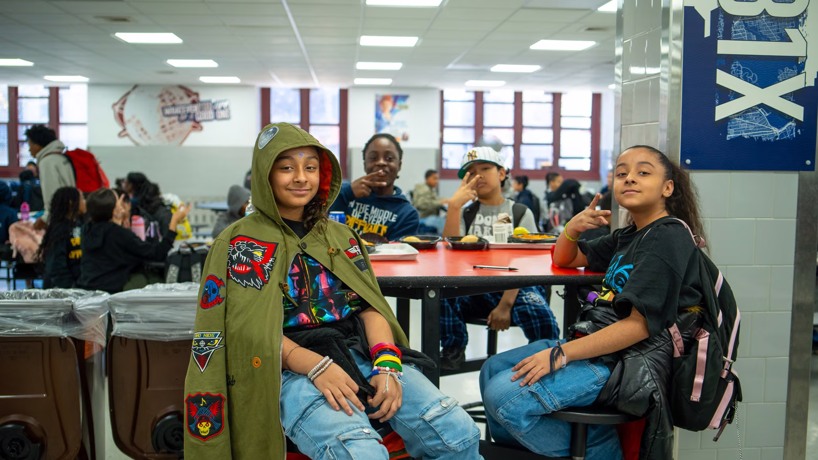 Students posing at a cafeteria table on Superhero Day