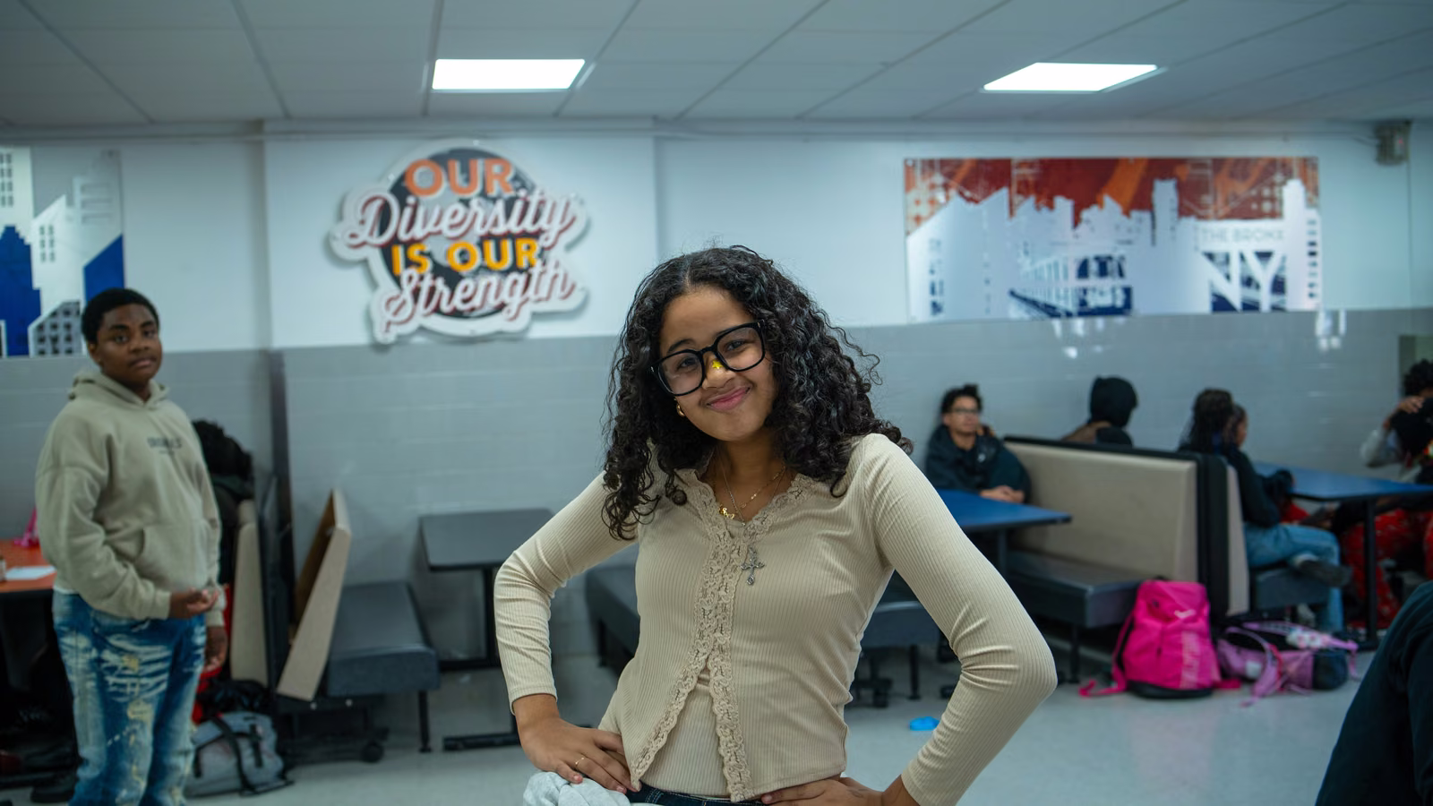 Student smiling in front of the Our Diversity Is Our Strength sign