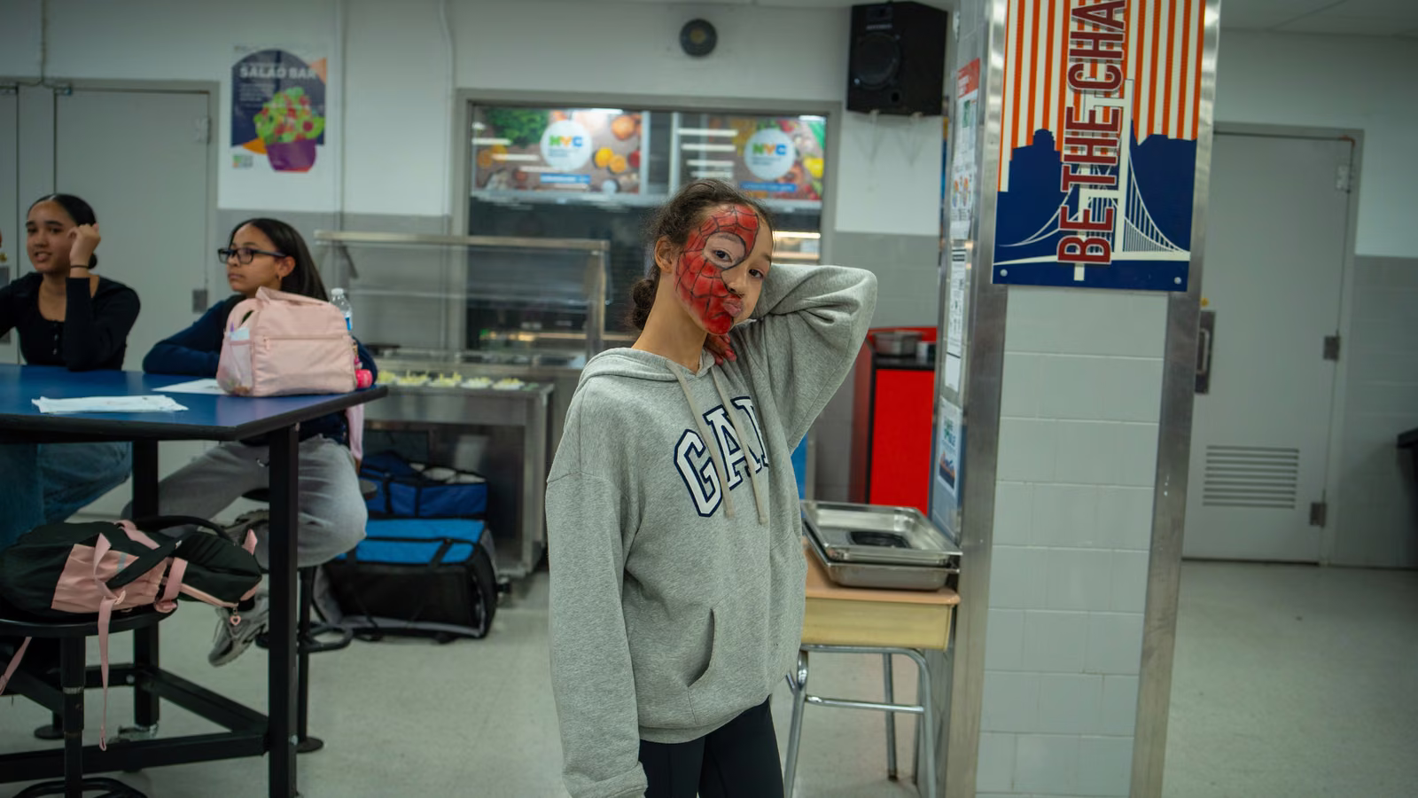 Student with Spider-Man face paint posing in the cafeteria