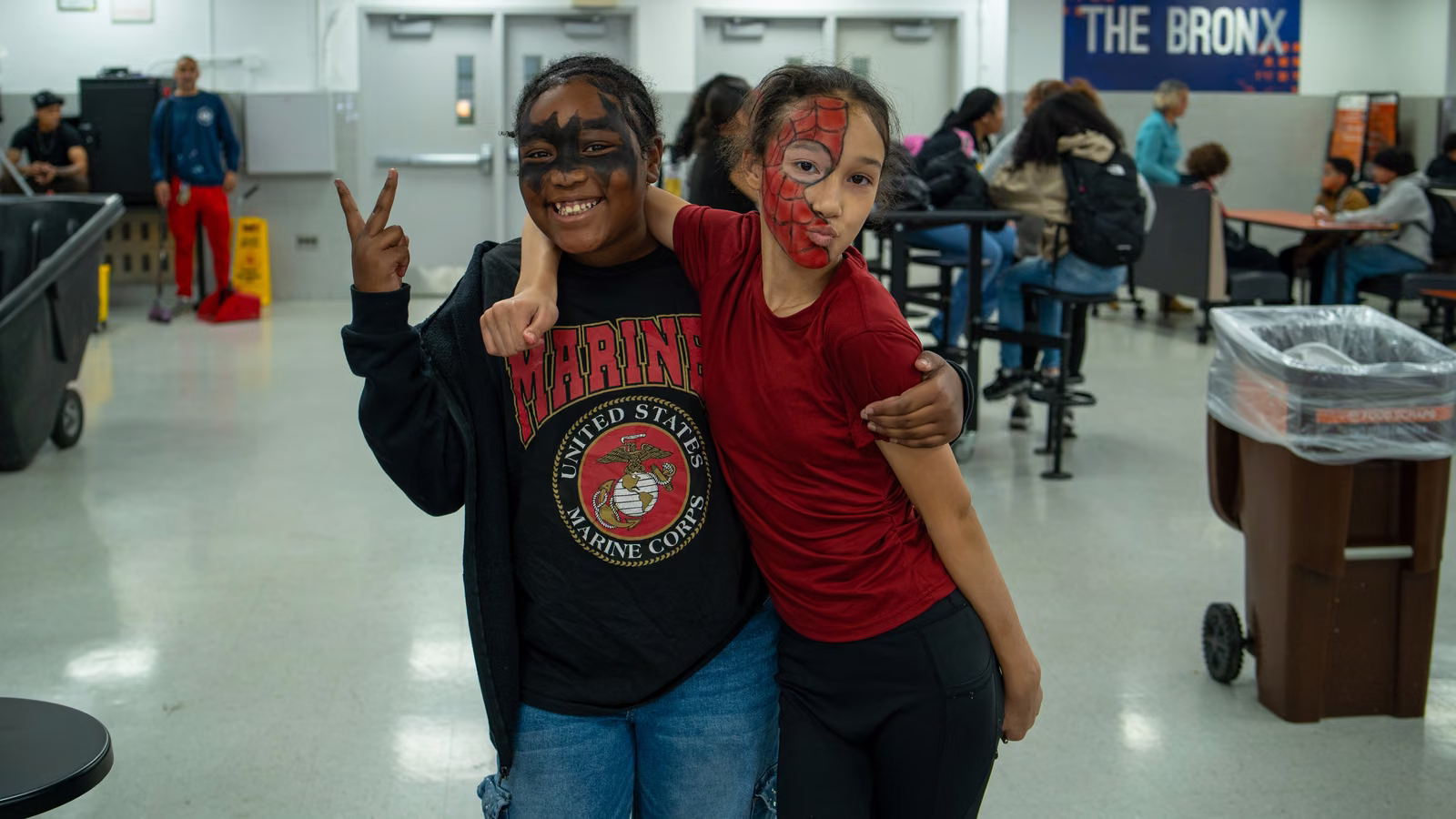 Two students in superhero face paint posing together