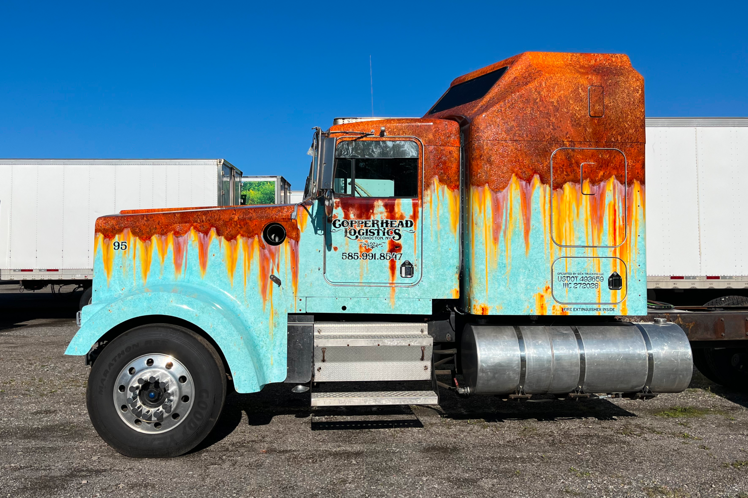 Side view of a semi-truck with a rusty patina wrap.