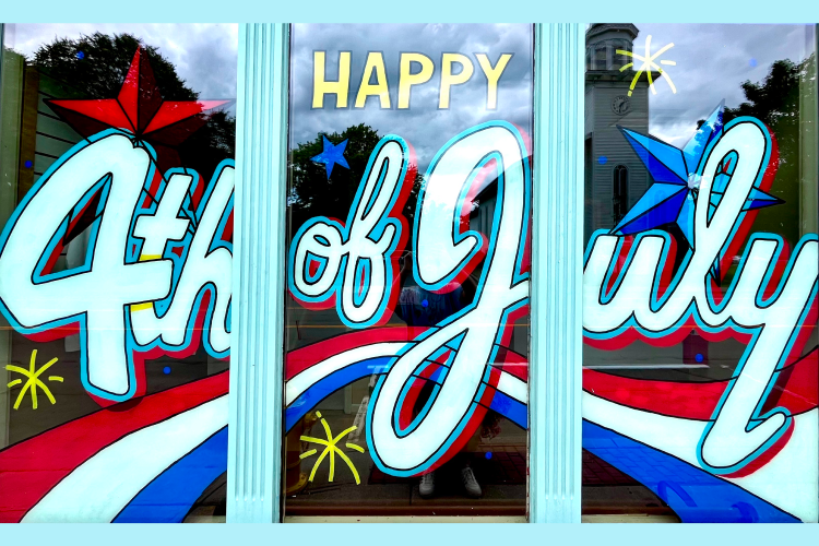 Window with stars, red, white, and bule stripes, and the words "Happy 4th of July" painted in white cursive letters. 
