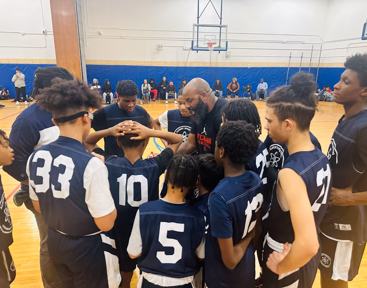 Boys basketball team huddles with coach during a game