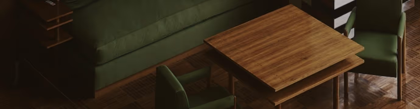 Wooden table surrounded by green upholstered chairs and a green sofa on a parquet floor.