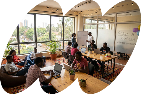 Image showing a common area of a startup office with some people working on their laptops.