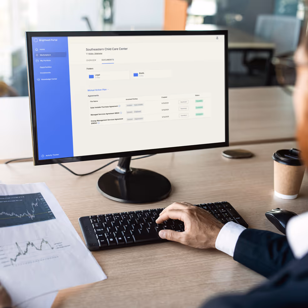 Person working at a computer desk viewing a contract management interface for Southeastern Child Care Center on the monitor.