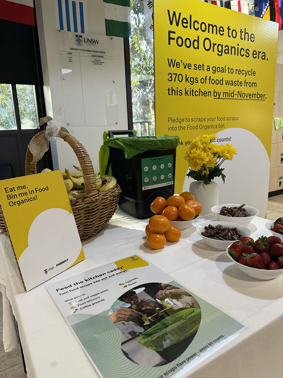 Information point for food organics recycling with a sign committing to reducing food waste.