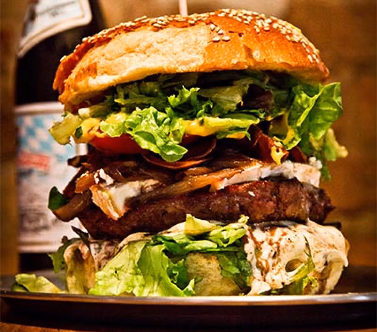 Ein großer gestapelter Burger mit mehreren Schichten Fleisch und Salat