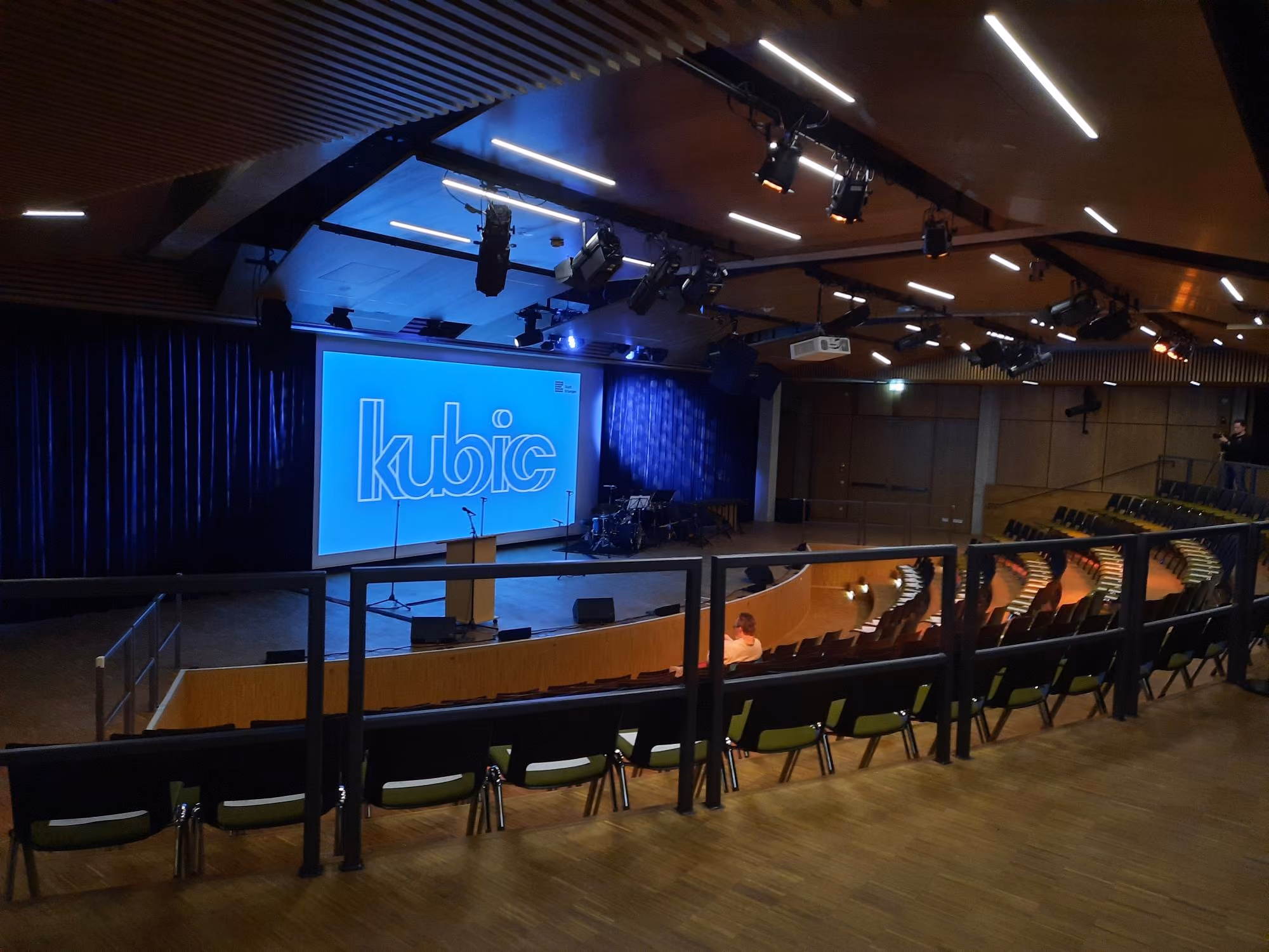 Ein Blick in den großen Konzertsaal des kubic. Auf die sehr große Leinwand ist das Wort lubic projiziert