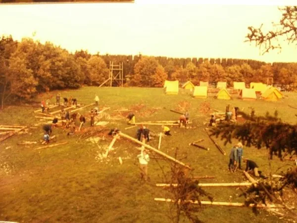 An old photo of tents and log cabins being built on grasslands