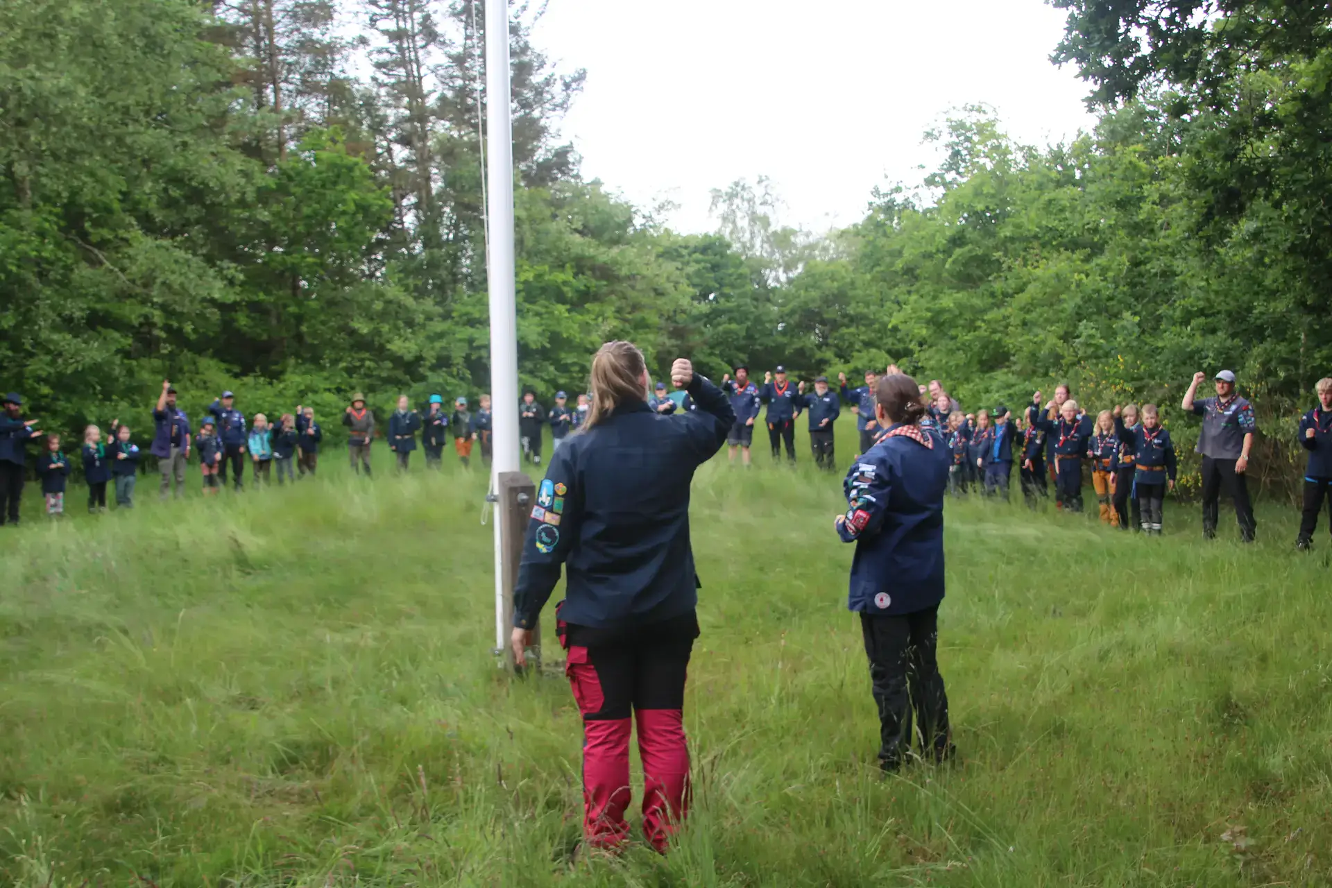 A couple of scout leaders cheering on a crowd
