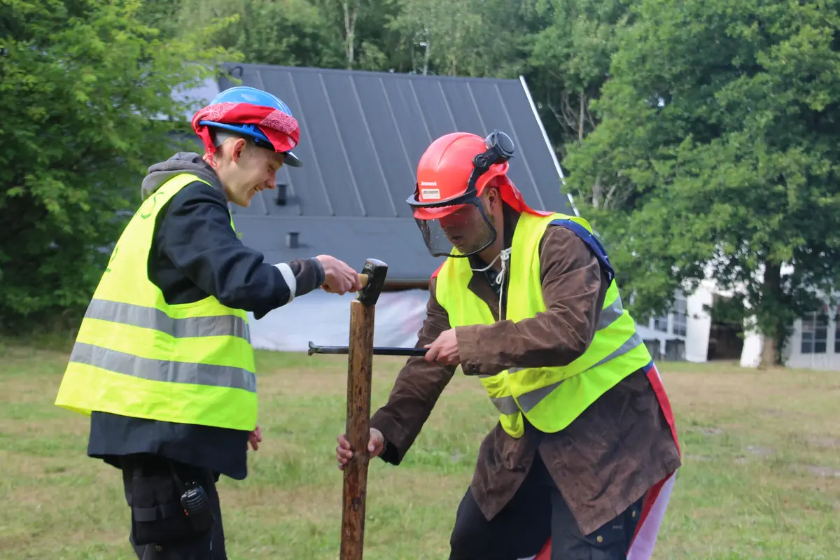 Two scout team members setting up a wooden stick