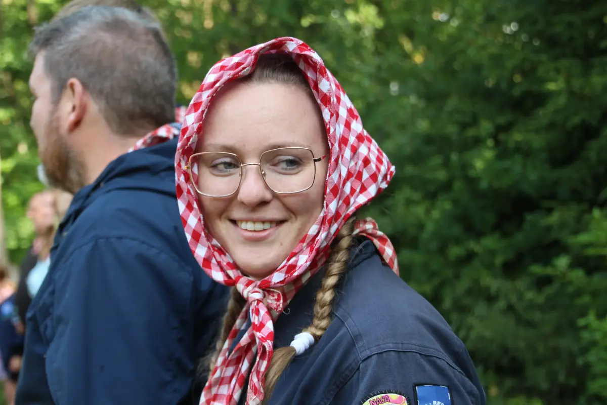 A woman with a scout's scarf over her head
