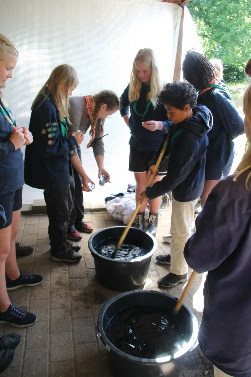 A group of kids preparing something in water buckets