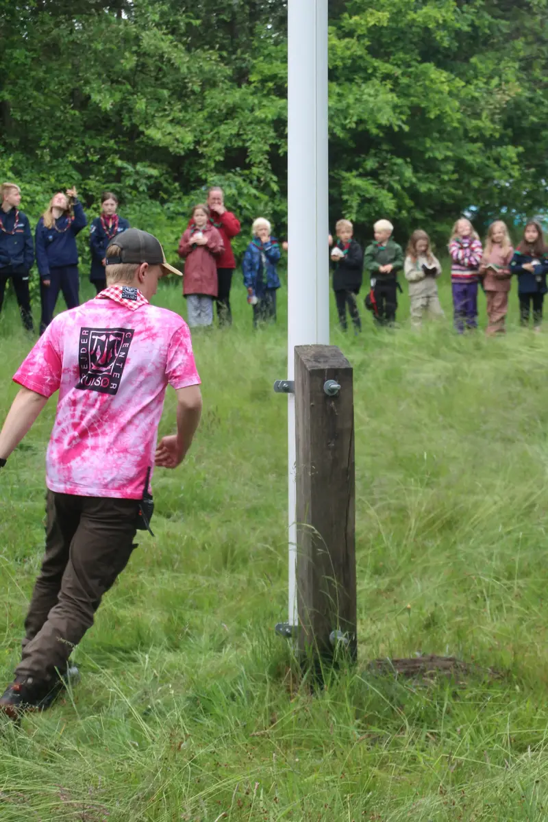 A scout running around a flagpole