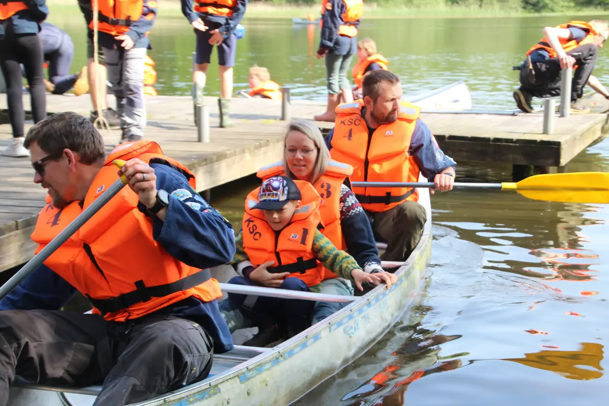 A group of people about to take their canoe out onto a lake