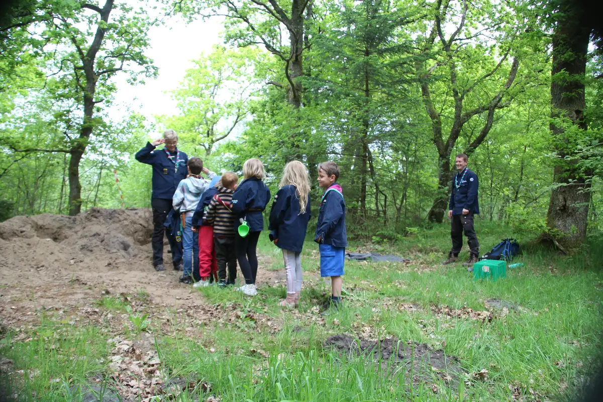 An instructor giving directions to a group of kids in the woods