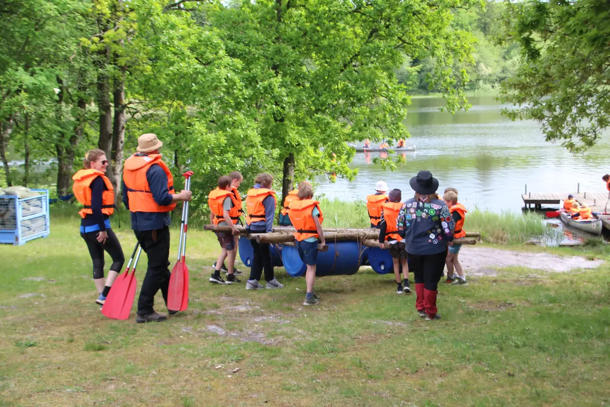 A group of people carrying a raft to the water