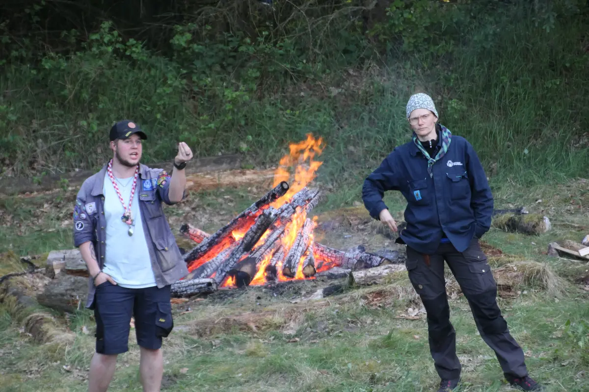 Two people in front of a bonfire