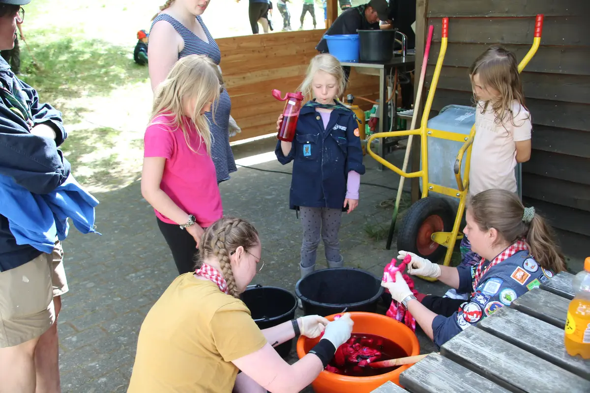A group of kids around buckets of water