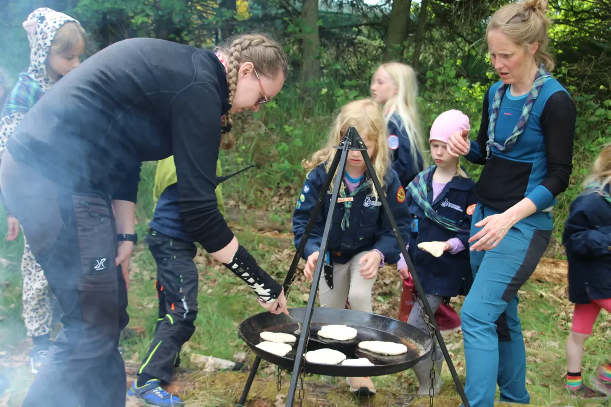 A group of people making pancakes in nature