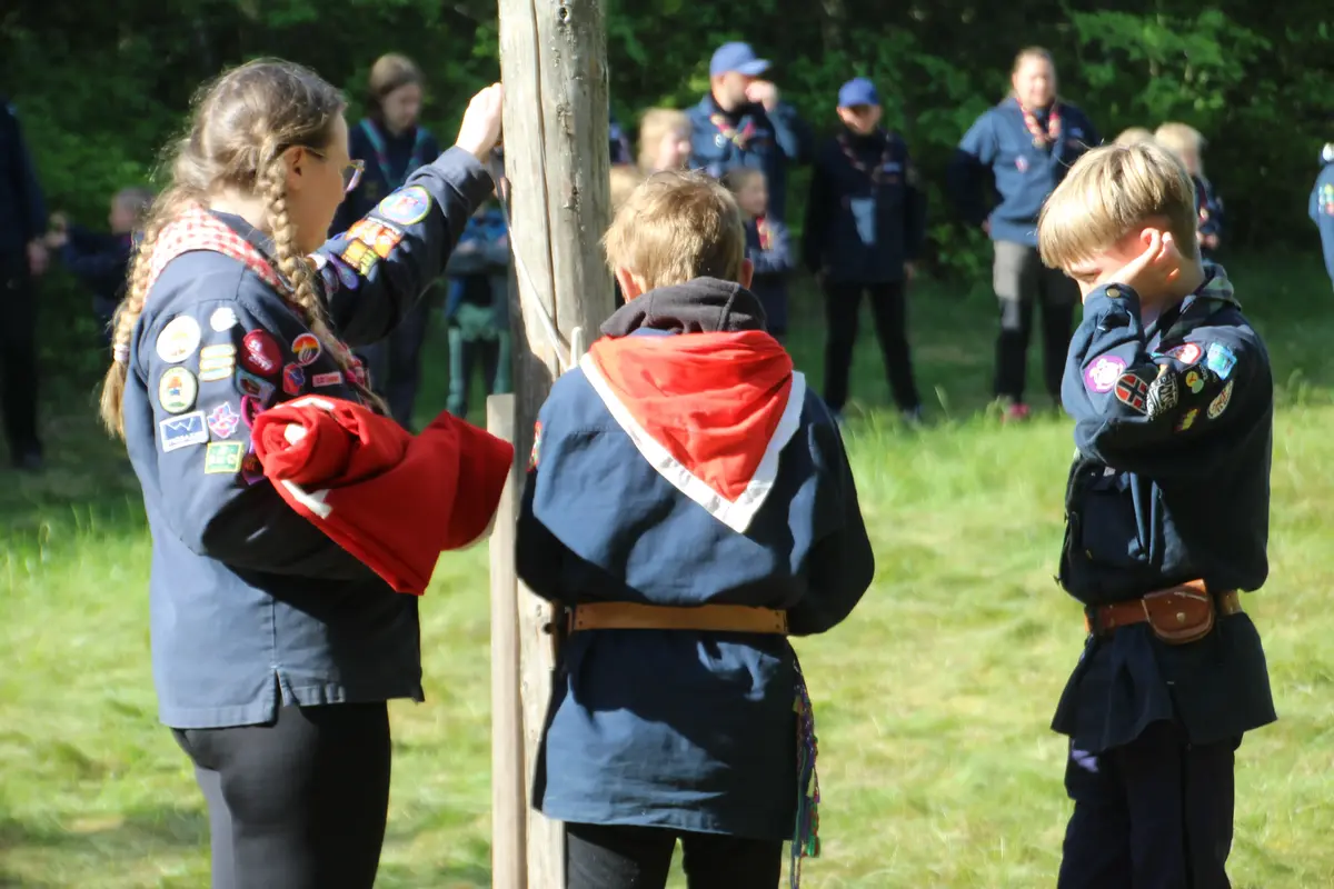 Three kids by a flagpole