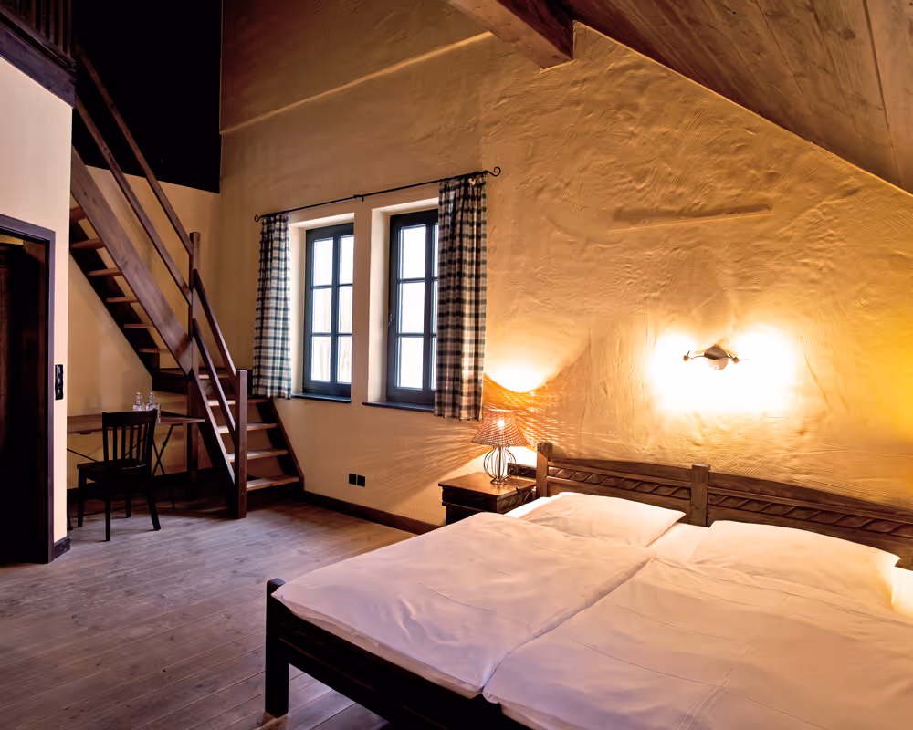 Übernachten mit Charme: Gemütliches Hotelzimmer im Landhausstil mit Galerie und rustikalem Holzausbau im Vielanker Brauhaus.