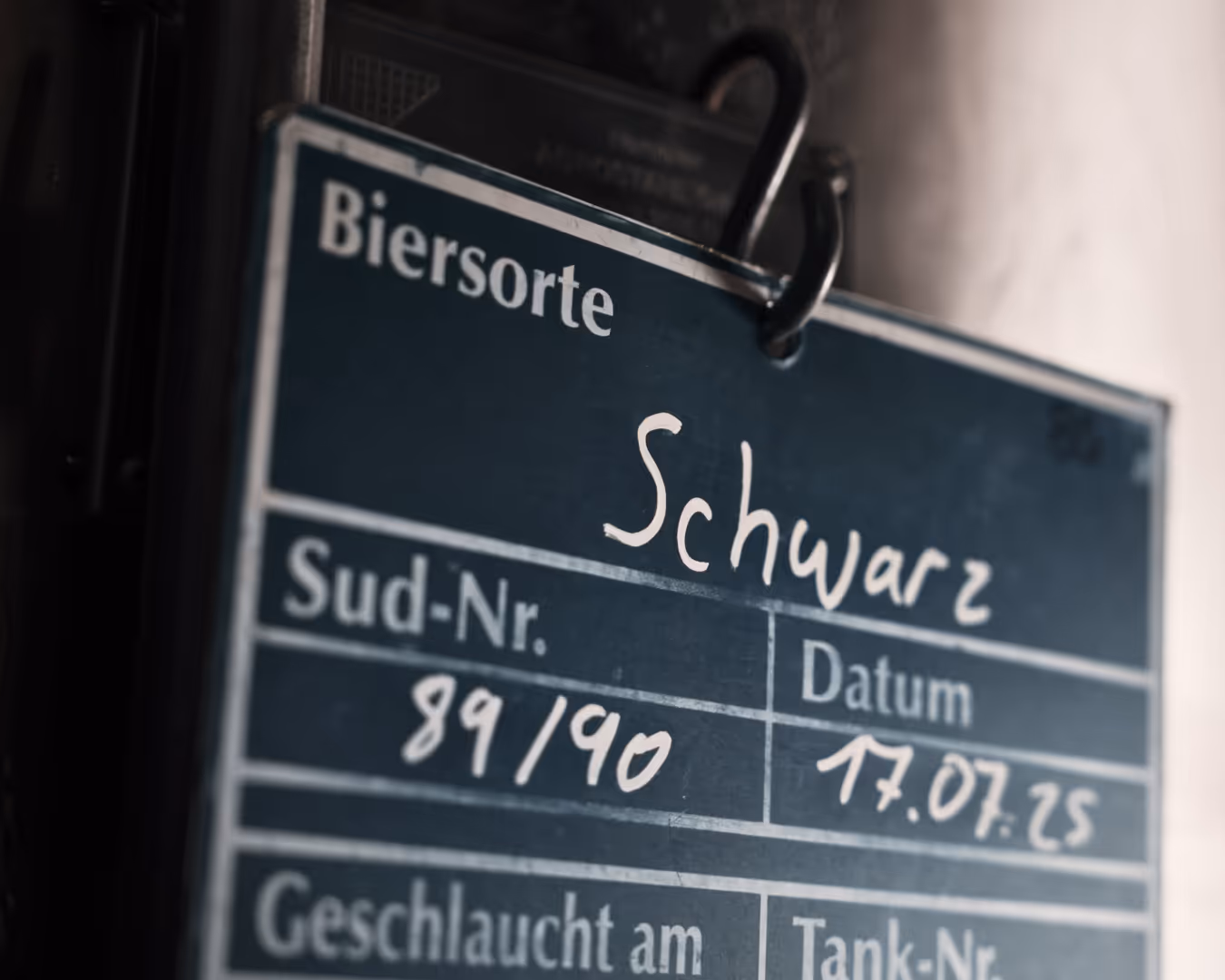 Dokumentation der Braukunst: Handbeschriebene Sudhaus-Tafel mit aktueller Sudnummer und Datum der Einbrauung.