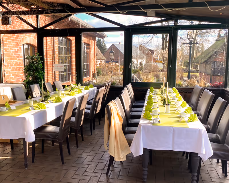 Lichtdurchfluteter Wintergarten für Familienfeiern und Bankette: Festlich gedeckte Tafeln mit Blick auf das historische Brauhaus-Gelände.
