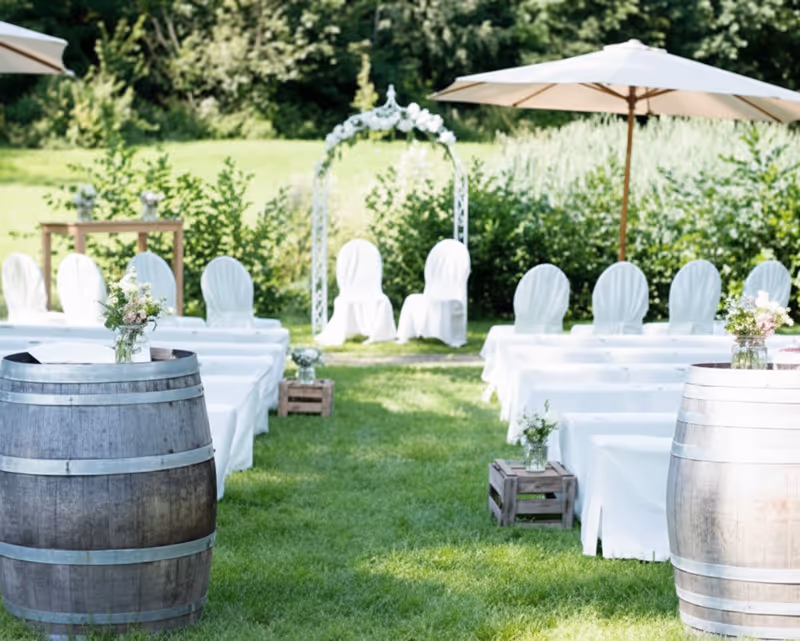 Traumhafte Hochzeitslocation im Grünen: Festliche Bestuhlung und romantischer Blumenbogen für eine freie Trauung im Vielanker Garten.