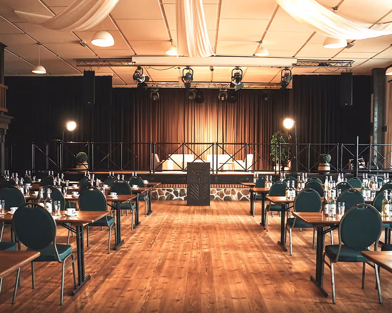 Großer Tagungssaal im Vielanker Brauhaus mit Parkettboden, professioneller Bestuhlung und Bühne für Konferenzen und Seminare in Mecklenburg.