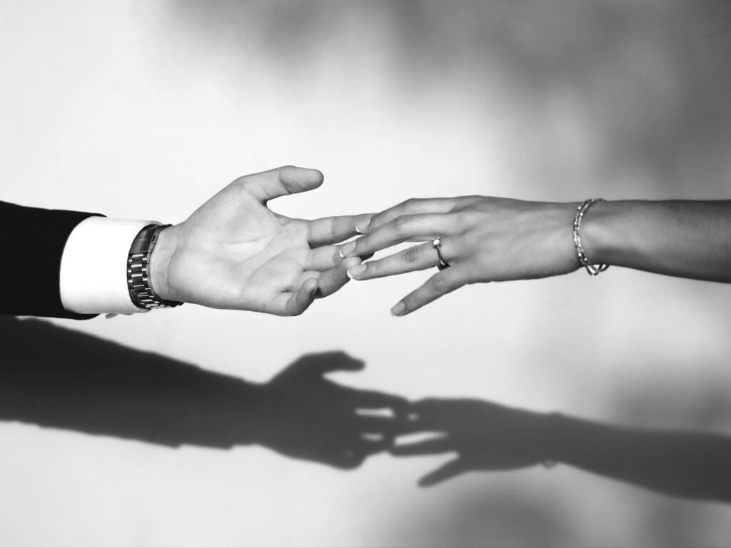 A black and white photo of a man and woman holding hands