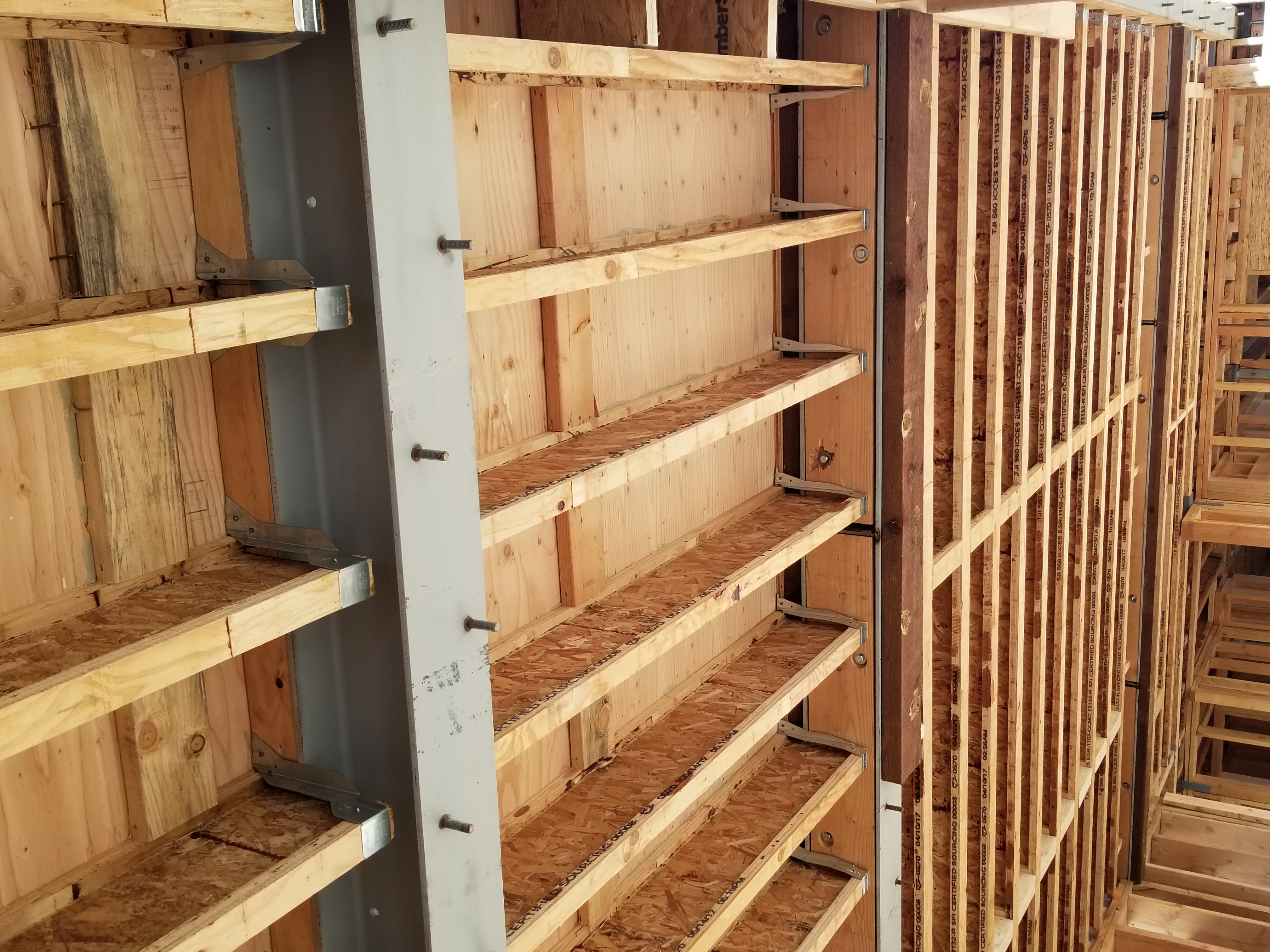 Exposed wooden floor joists and ceiling beams in new home construction showing structural framing and engineered lumber