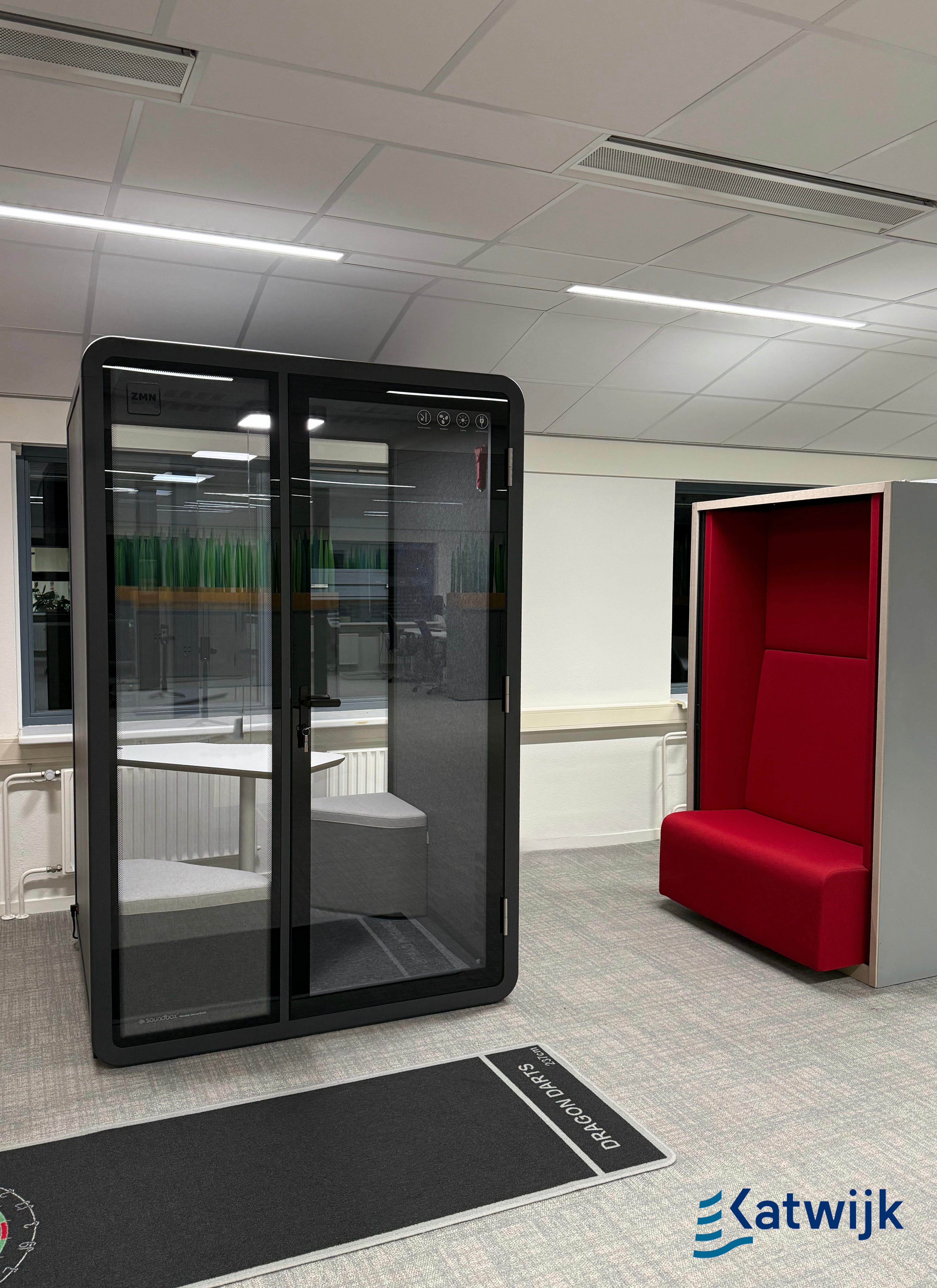 Two men standing outdoors leaning on a metal rail in front of a building entrance.